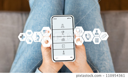 Woman at home using medical app on smartphone to access healthcare services 110954361