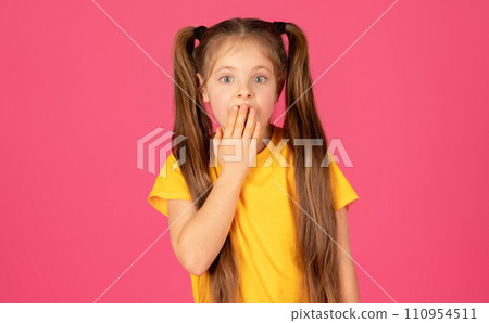 Astonished young girl covering mouth in shock and looking at camera 110954511