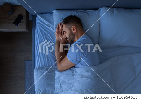 Guy Sleeping Holding Hands Near Face Enjoying Rest In Bedroom 110954515