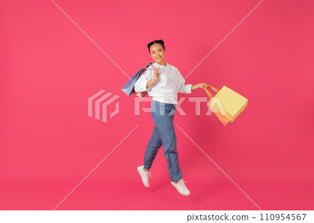 Sales Concept. Beautiful Happy Asian Woman Jumping With Shopping Bags In Hands 110954567