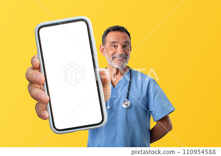 Mature medical worker man in uniform demonstrating smartphone screen, studio 110954588