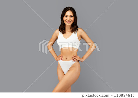 Positive caucasian slim young woman in white underwear show perfect body after weight loss Positive caucasian slim young woman in white underwear show perfect body after weight loss 110954615