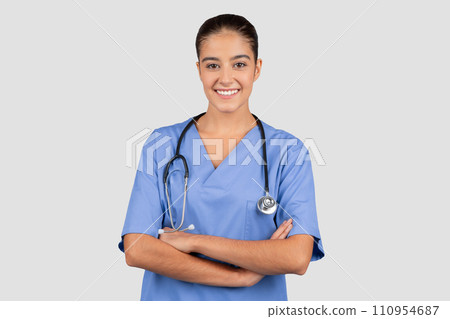 Happy confident european millennial doctor or nurse in blue uniform with crossed arms 110954687