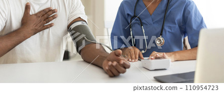 Doctor Woman Measuring Arterial Blood Pressure Of Male Patient In Clinic, Cropped Doctor Woman Measuring Arterial Blood Pressure Of Male Patient In Clinic, Cropped 110954723