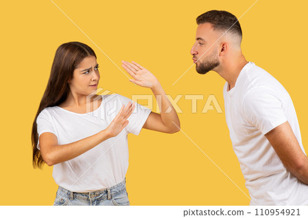 Angry millennial european woman in white t-shirt stop man, wants kiss Angry millennial european woman in white t-shirt stop man, wants kiss 110954921
