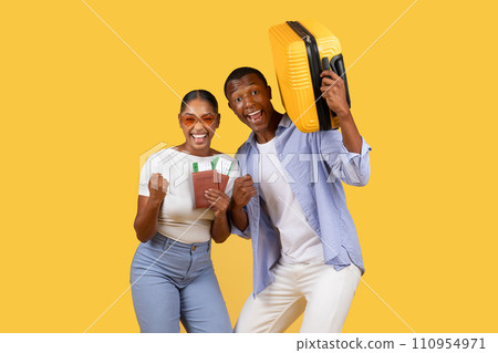 Joyful black couple with suitcase and passports Joyful black couple with suitcase and passports 110954971