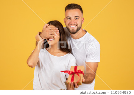 Positive millennial european husband closed eyes to wife, gives box present Positive millennial european husband closed eyes to wife, gives box present 110954980