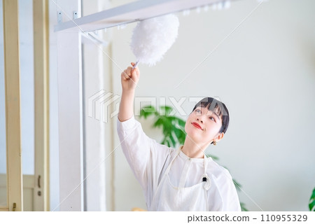 年輕女子清理房間每個角落的灰塵 年輕女子清理房間每個角落的灰塵 110955329