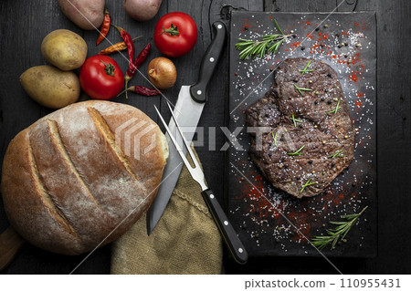 Beef steak seasoned with salt, pepper and fresh hearbs searved in the kitchen. Top view, flat lay 110955431