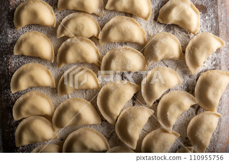Raw dumplings varenik on wooden board close up 110955756