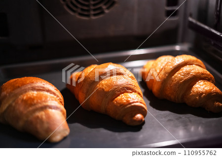 Three croissants are baked in the home oven Three croissants are baked in the home oven 110955762