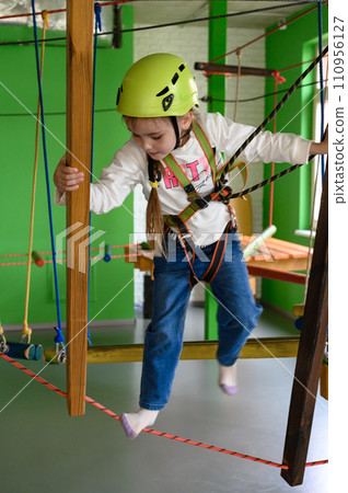A little girl walks on a cableway, a playroom with a cable car. A little girl walks on a cableway, a playroom with a cable car. 110956127