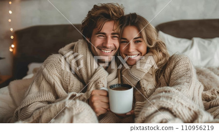 Young and happy couple in pajamas drinking coffee in bed 110956219