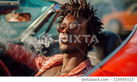 Young black man sitting and smoking in a red sports car 110956515
