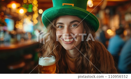 Young cheerful woman in a big green leprechaun hat drinks beer in an Irish pub Young cheerful woman in a big green leprechaun hat drinks beer in an Irish pub 110956552