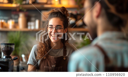A cheerful barista engaging in conversation with a guest at the bar counter A cheerful barista engaging in conversation with a guest at the bar counter 110956920