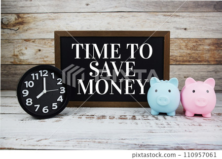 Time to save money text message on chalkboard with alarm clock and piggy saving Time to save money text message on chalkboard with alarm clock and piggy saving 110957061