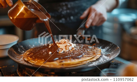 a cook in a street cafe spreads chocolate spread on a pancake a cook in a street cafe spreads chocolate spread on a pancake 110957062