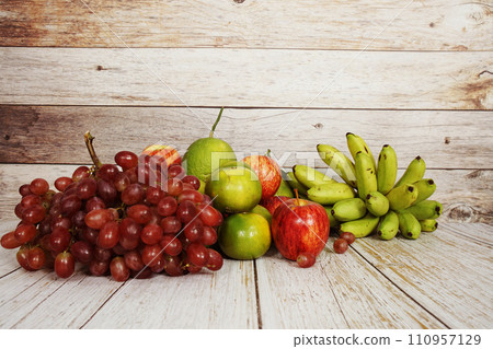 Various of fruits with Red grape, red apple, banana and green orange on wooden background 110957129