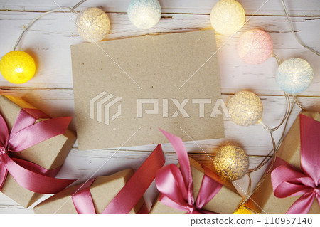 Empty Paper Caft with LED cotton balls and gift boxes on wooden background 110957140