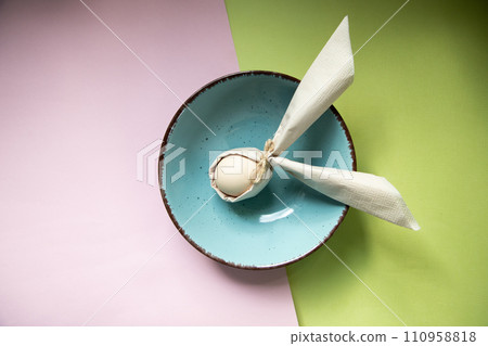 egg wrapped in easter bunny shaped napkin egg wrapped in easter bunny shaped napkin 110958818