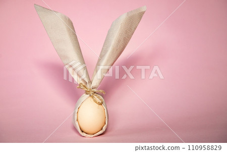 egg wrapped in easter bunny shaped napkin egg wrapped in easter bunny shaped napkin 110958829