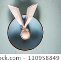 egg wrapped in easter bunny shaped napkin 110958849