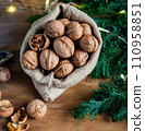 festive christmas nuts tumbling from a burlap bag 110958851