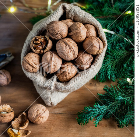 festive christmas nuts tumbling from a burlap bag 110958851
