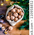 festive christmas nuts tumbling from a burlap bag 110958852