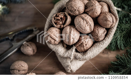 festive christmas nuts tumbling from a burlap bag 110958854