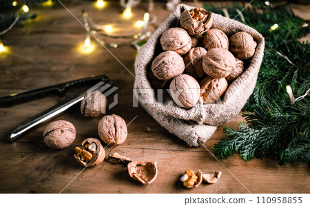 festive christmas nuts tumbling from a burlap bag 110958855