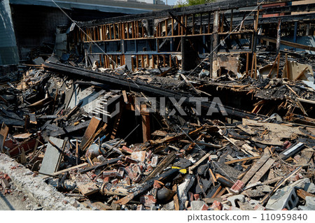 A burnt-out old wooden building after a fire. Charred beams after the destruction. A burnt-out old wooden building after a fire. Charred beams after the destruction. 110959840