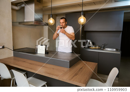 Young adult man drinking coffee at home 110959903
