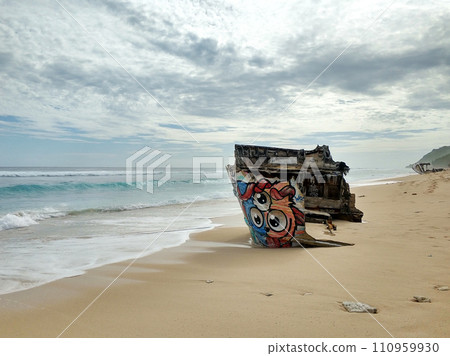 The wreckage of a wooden ship on a sandy beach on the ocean. The shipwreck 110959930