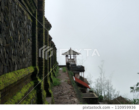 The stark stone wall of the temple on the mountain is covered with moss. 110959936