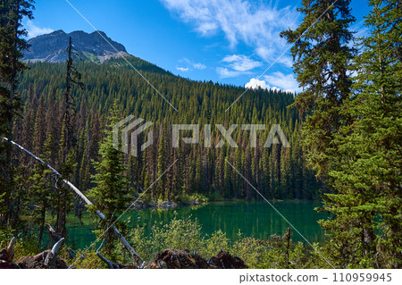 Incredibly beautiful transparent emerald calm lake with reflection of rocky mountain on the Black Prince Cirque Trail. Majestic Canadian mountains with snow on sunny summer day in Alberta, Kananaskis. Incredibly beautiful transparent emerald calm lake with reflection of rocky mountain on the Black Prince Cirque Trail. Majestic Canadian mountains with snow on sunny summer day in Alberta, Kananaskis. 110959945