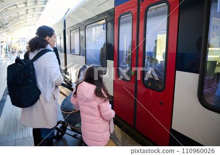 People. mom and daughter boarding embarking a high-speed train and travel from city to another using public transport 110960026