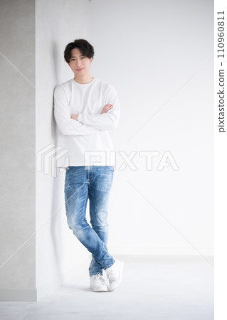 年輕英俊的男人靠在牆上,交叉雙臂 年輕英俊的男人靠在牆上,交叉雙臂 110960811