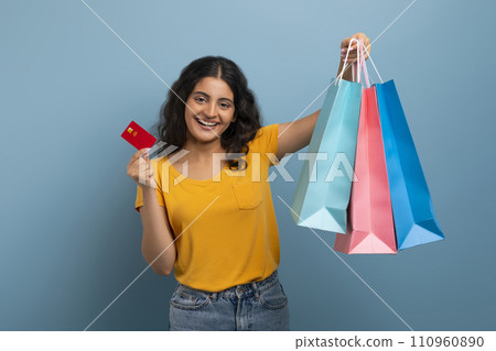 Happy young eastern lady with shopping bags and credit card Happy young eastern lady with shopping bags and credit card 110960890