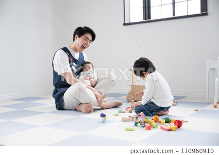 Nursery teacher playing with children at nursery school 110960910