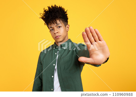 Serious tired young black man showing stop gesture 110960988