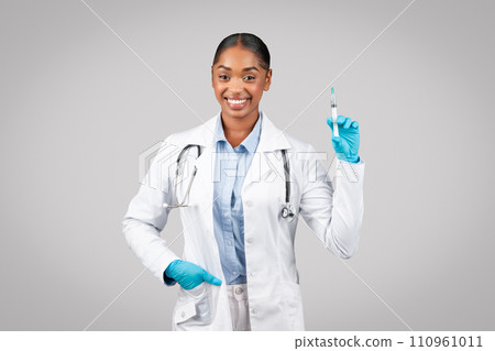 Positive millennial black woman doctor in white coat, protective gloves use syringe, recommendation vaccination 110961011