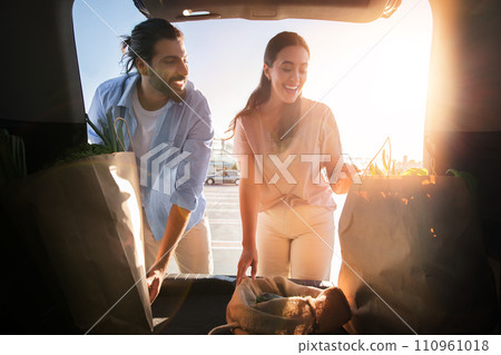 Middle eastern couple with groceries at car trunk Middle eastern couple with groceries at car trunk 110961018