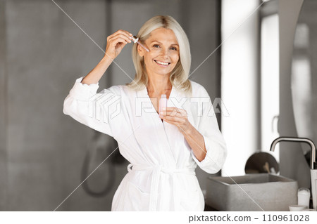 Skincare Concept. Beautiful Mature Woman Applying Face Serum With Droplet 110961028