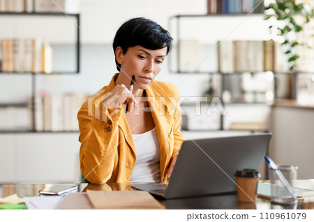 Pensive Lady Entrepreneur Thinking Looking At Laptop In Modern Office 110961079