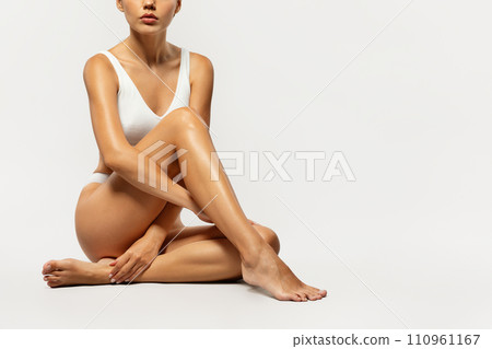 Serious european slim millennial lady in underwear sitting on floor, enjoy spa treatment 110961167