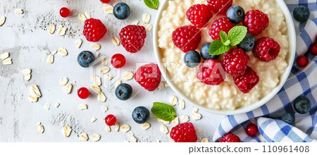 Healthy oatmeal porridge with berries on white table   top view of nourishing and diet breakfast 110961408
