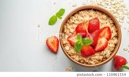 Healthy oatmeal porridge bowl with strawberry on white table, top viewdiet breakfast concept. 110961554