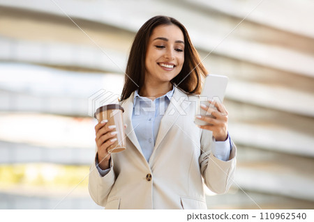 Smiling pretty confident young european woman in suit enjoy work, cup of coffee takeaway 110962540